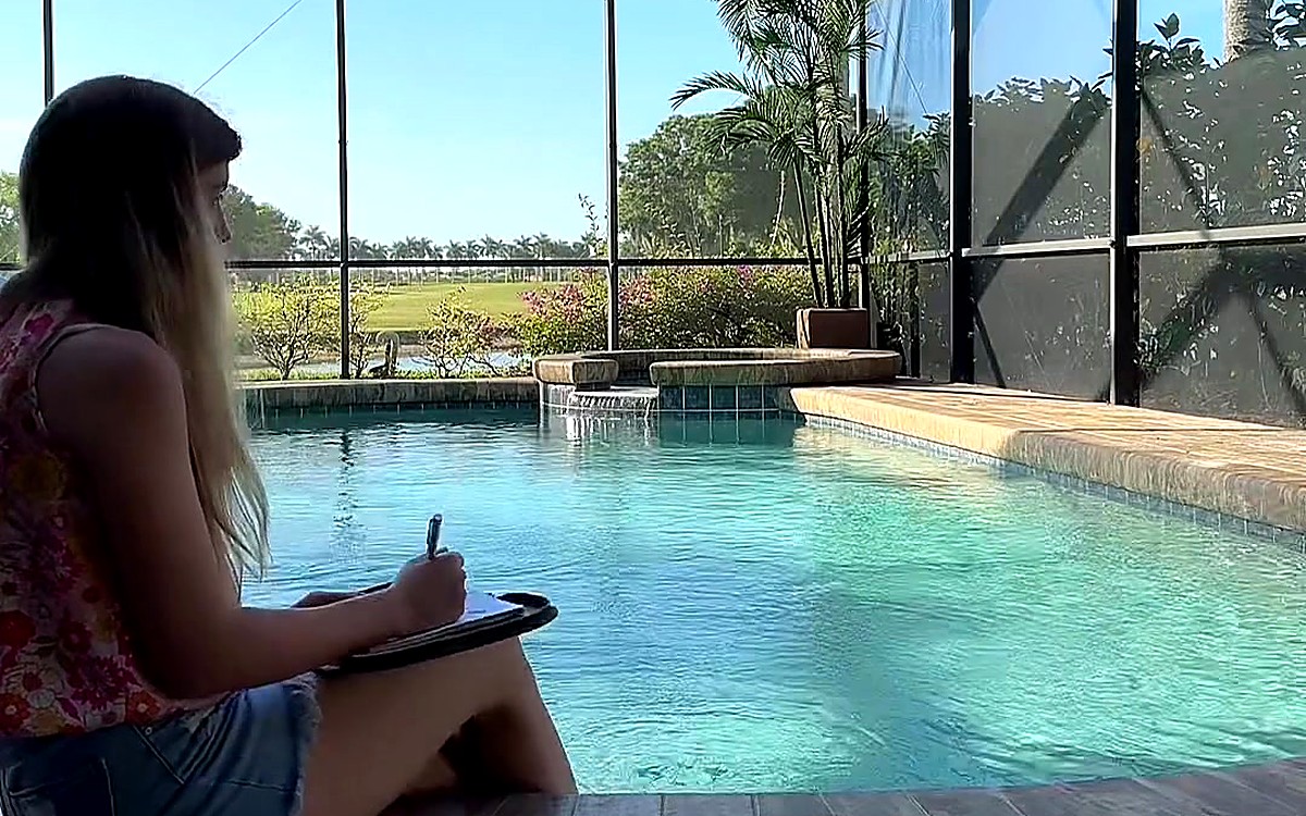 Woman writing beside a pool