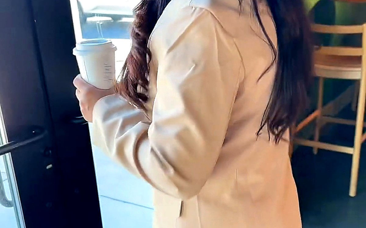 Woman in a beige blazer heading out the door